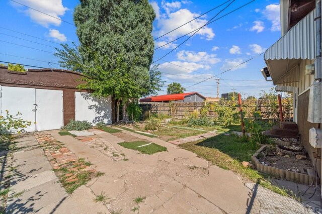 view of yard featuring fence and a patio