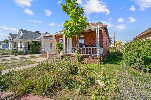 view of front of home featuring a porch and brick siding