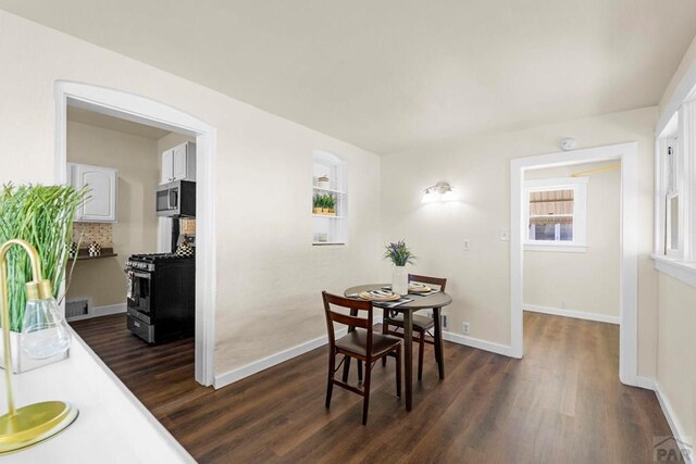 dining area featuring visible vents, dark wood finished floors, and baseboards