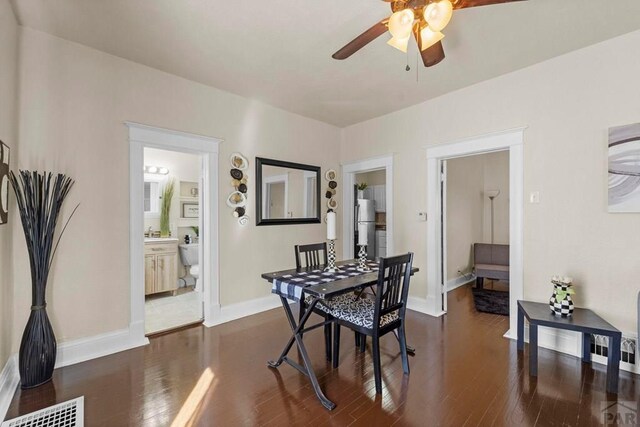 dining room with dark wood-style floors, visible vents, baseboards, and ceiling fan