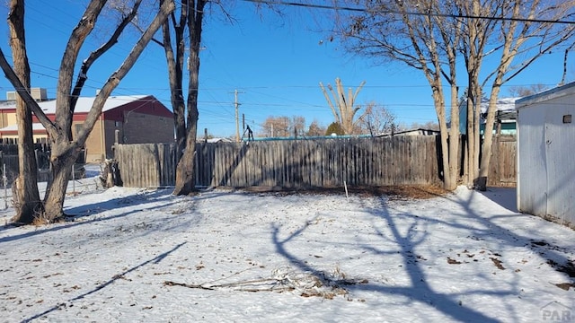 yard covered in snow featuring fence