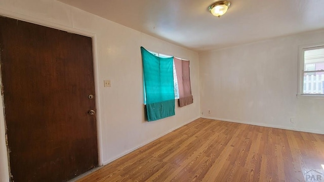 empty room featuring baseboards and light wood-style floors