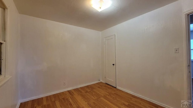 empty room featuring light wood finished floors and baseboards