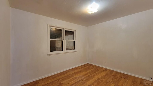 unfurnished room featuring light wood-type flooring and baseboards