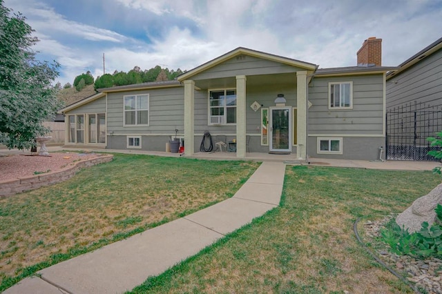 view of front of house with a chimney, fence, and a front lawn