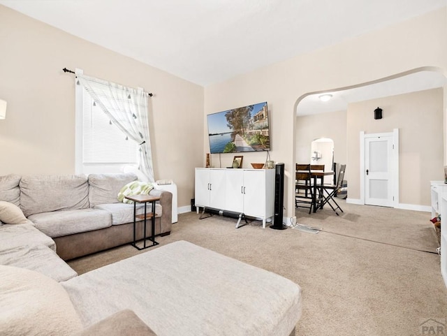 309 Quincy St, Pueblo, CO 81004 - carpeted living room featuring arched walkways and baseboards