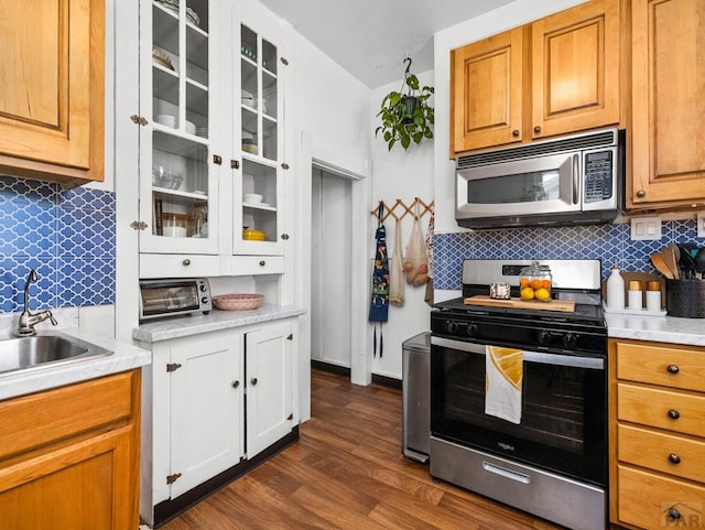 309 Quincy St, Pueblo, CO 81004 - kitchen featuring appliances with stainless steel finishes, decorative backsplash, light countertops, and a sink