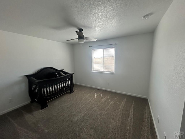 bedroom featuring baseboards, a textured ceiling, dark carpet, and ceiling fan