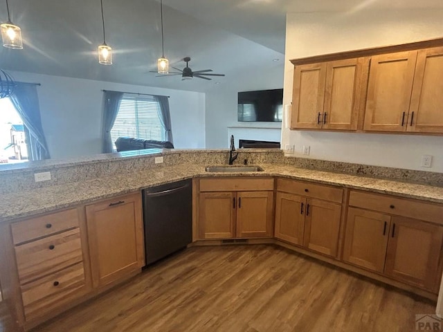 kitchen featuring light stone countertops, a sink, dishwasher, wood finished floors, and pendant lighting