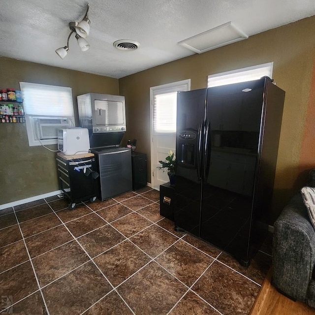 kitchen with a textured ceiling, black refrigerator with ice dispenser, dark tile patterned floors, and visible vents