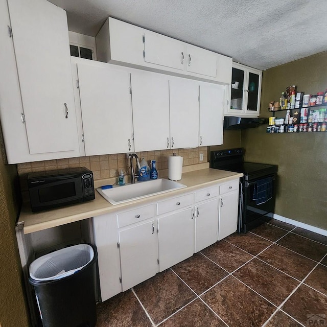 kitchen featuring under cabinet range hood, light countertops, black appliances, white cabinetry, and a sink