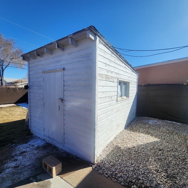 view of outbuilding with fence and an outbuilding