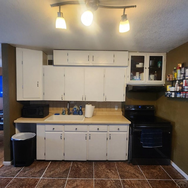 kitchen with white cabinets, a sink, hanging light fixtures, and black appliances