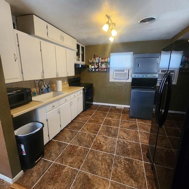 kitchen with light countertops, glass insert cabinets, white cabinets, a sink, and black appliances