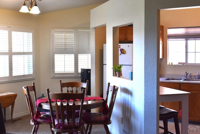 dining room featuring a notable chandelier, baseboards, and a healthy amount of sunlight