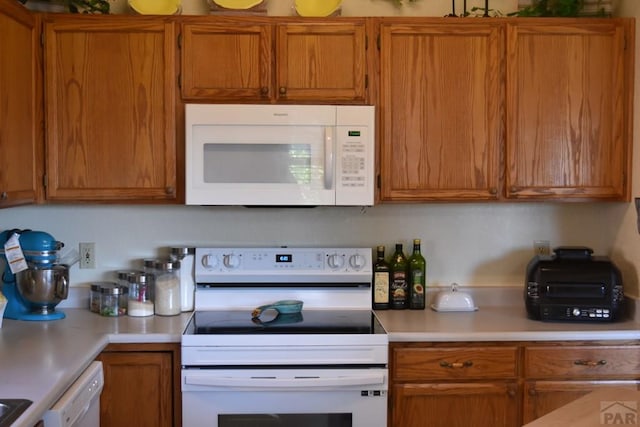 135 S Stardust Cir, Pueblo West, CO 81007 - kitchen featuring light countertops, white appliances, and brown cabinets