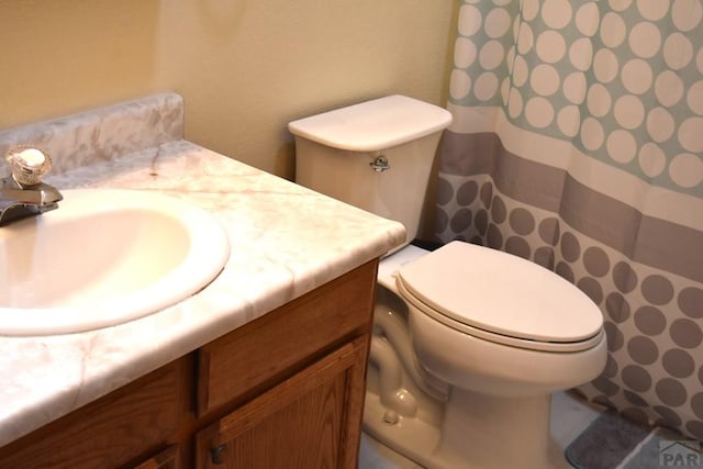 bathroom with toilet, curtained shower, and vanity