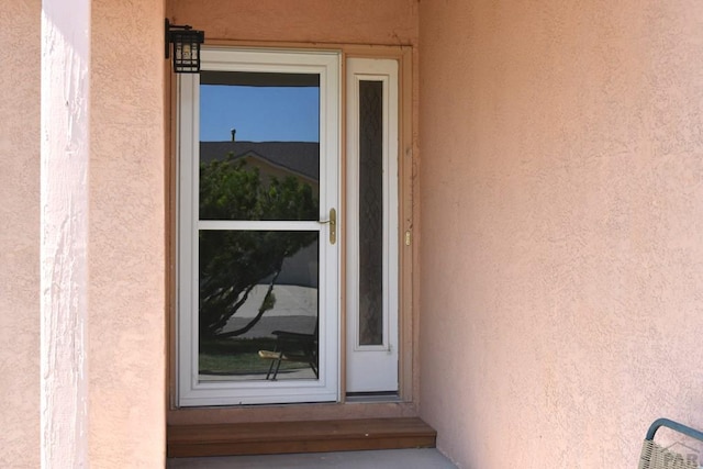 view of exterior entry featuring stucco siding