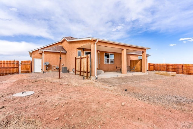 back of property featuring central AC unit, a patio area, a fenced backyard, and stucco siding