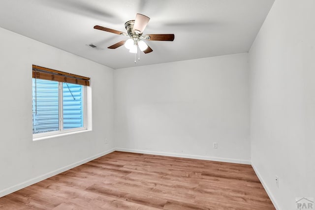 empty room with visible vents, light wood-style flooring, and baseboards