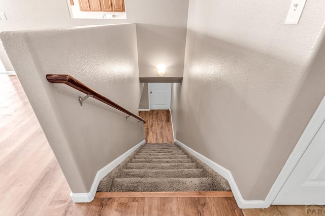 stairs featuring baseboards and wood finished floors