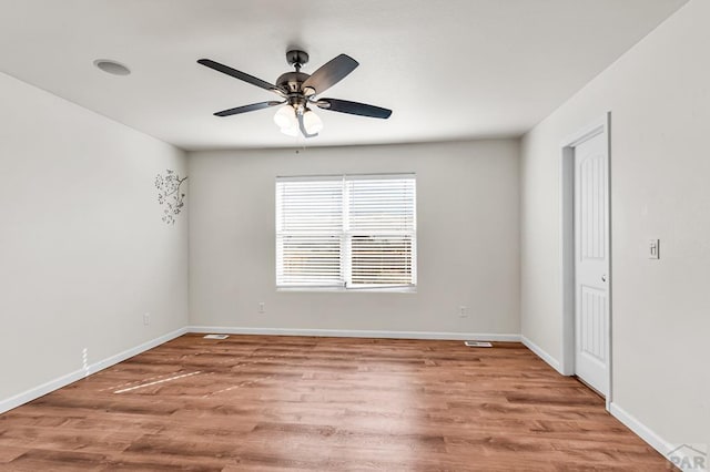 unfurnished room with a ceiling fan, light wood-style flooring, and baseboards