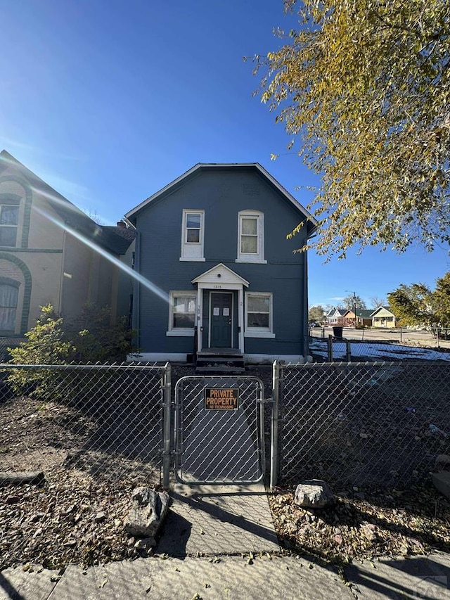 view of front of home featuring central AC unit, a fenced front yard, and a gate