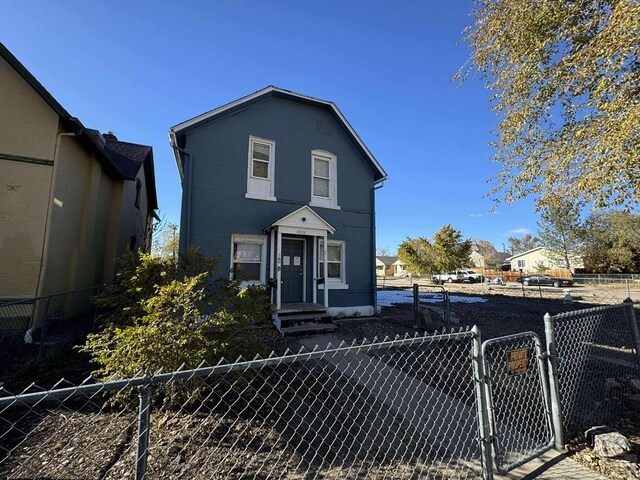 traditional home featuring a fenced front yard and a gate