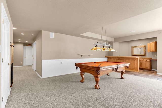 recreation room featuring light carpet, a textured ceiling, wainscoting, and recessed lighting