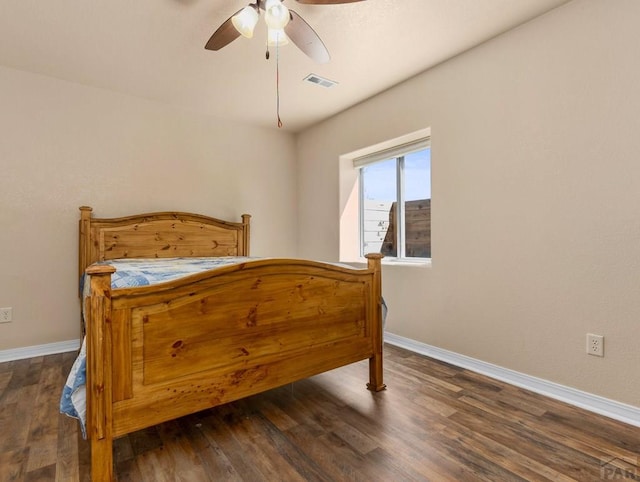 bedroom with baseboards, visible vents, and wood finished floors