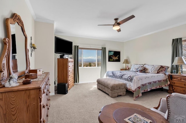 carpeted bedroom featuring a ceiling fan and crown molding