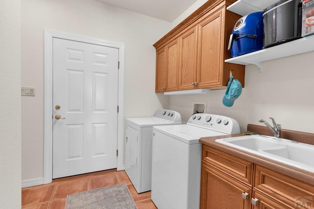 clothes washing area featuring cabinet space, light tile patterned floors, a sink, and washing machine and clothes dryer