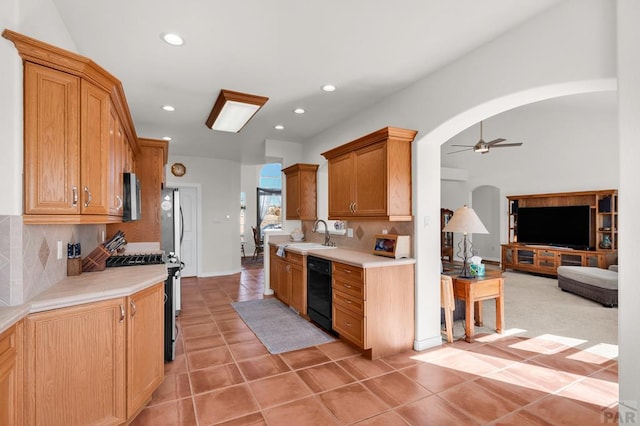 kitchen featuring arched walkways, a ceiling fan, appliances with stainless steel finishes, light countertops, and light tile patterned flooring