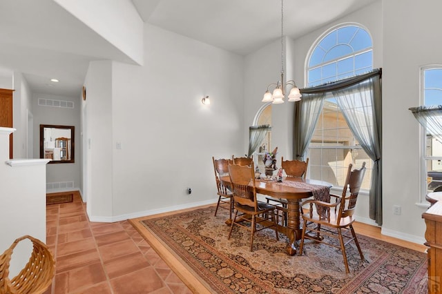 dining room with an inviting chandelier, baseboards, visible vents, and light tile patterned flooring