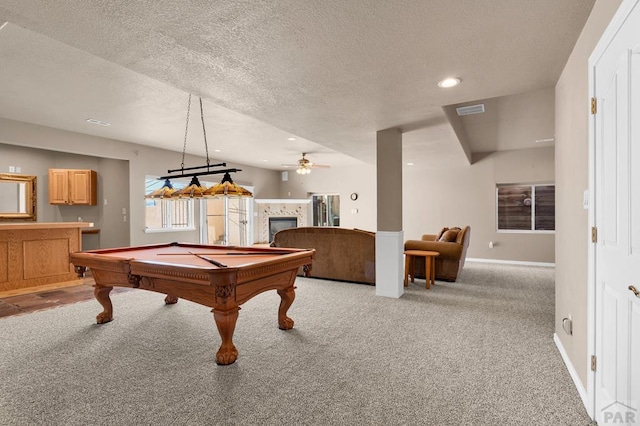 game room featuring a textured ceiling, a tile fireplace, recessed lighting, light carpet, and baseboards