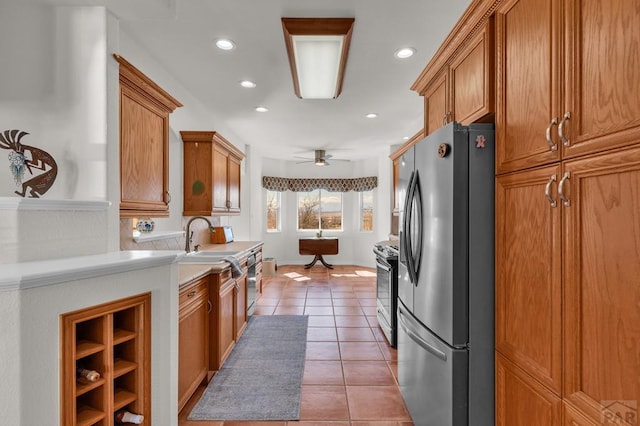 kitchen with stainless steel fridge with ice dispenser, brown cabinets, light tile patterned flooring, light countertops, and recessed lighting