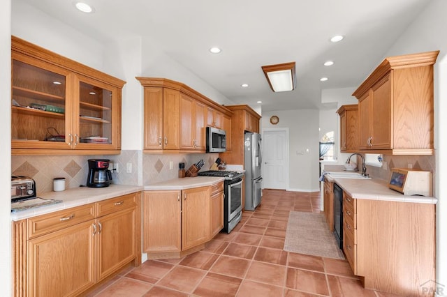 kitchen featuring light tile patterned floors, a sink, stainless steel appliances, light countertops, and backsplash