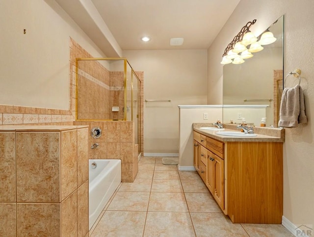 bathroom with a sink, tile patterned flooring, a tub to relax in, and tiled shower