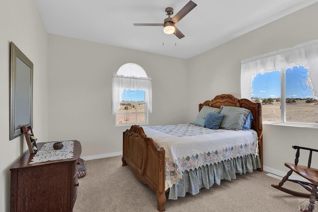 bedroom featuring ceiling fan, baseboards, and light colored carpet