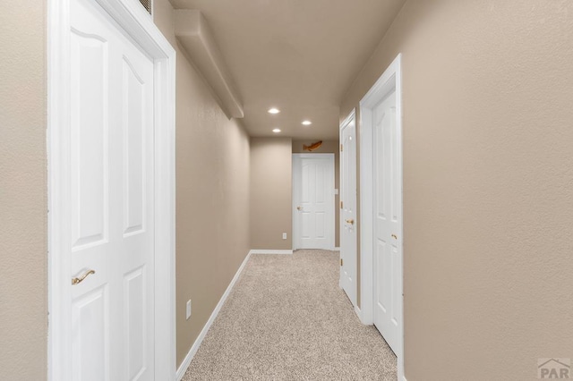 hallway featuring recessed lighting, light colored carpet, and baseboards