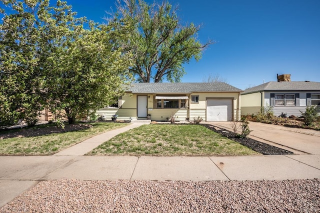 view of front facade with a garage, stucco siding, driveway, and a front yard