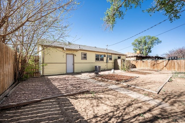 back of house featuring a fenced backyard, a patio, stucco siding, and central AC