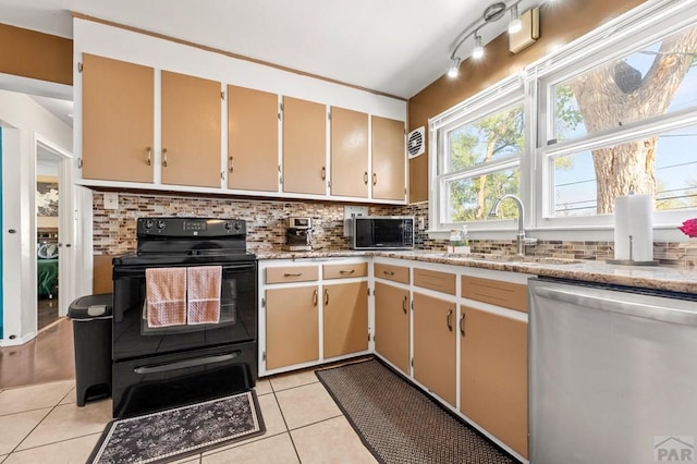 kitchen featuring backsplash, light tile patterned flooring, appliances with stainless steel finishes, and a sink