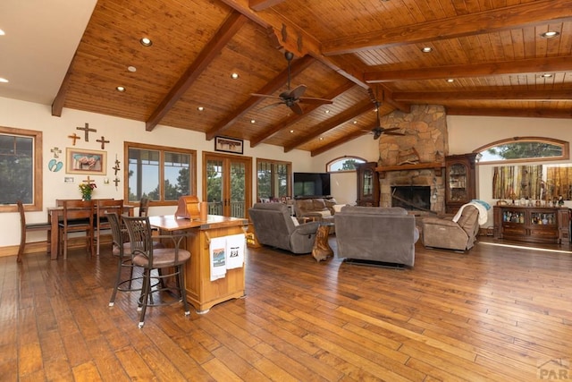 living room featuring wooden ceiling, beam ceiling, a fireplace, and hardwood / wood-style floors