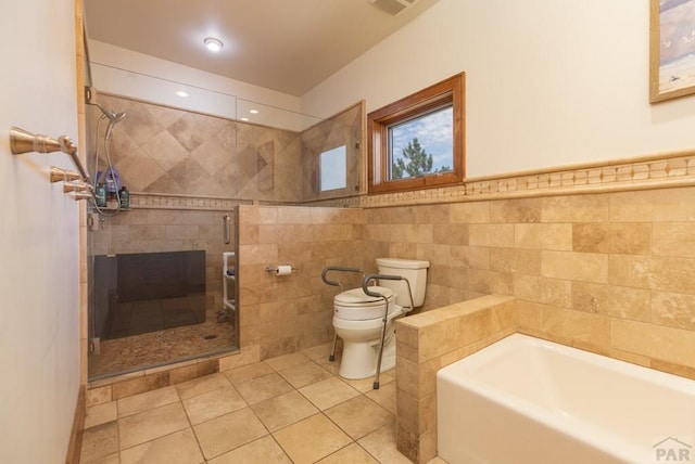 bathroom with toilet, tile patterned floors, a garden tub, a shower stall, and tile walls