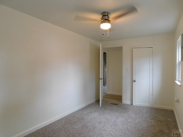 unfurnished bedroom with carpet floors, a ceiling fan, and baseboards