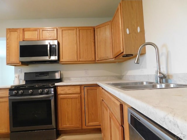 kitchen featuring stainless steel appliances, light countertops, and a sink