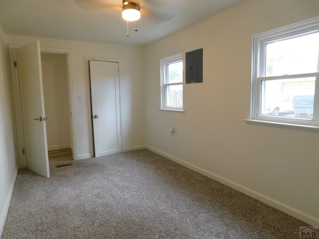 unfurnished bedroom with visible vents, carpet flooring, electric panel, and baseboards