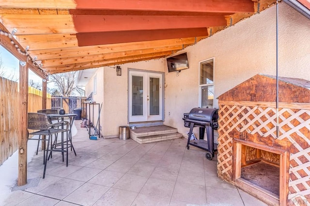 view of patio / terrace featuring a grill, a fireplace, fence, and french doors