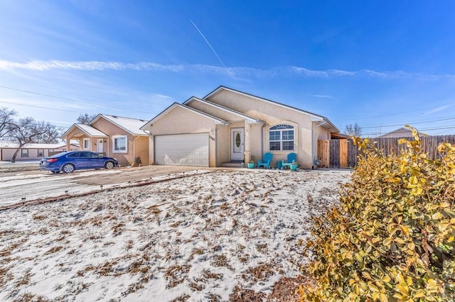 ranch-style home featuring a garage, concrete driveway, fence, and stucco siding